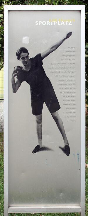A sign with a picture of Lilli Henoch preparing for the shot put, with a brief biography written in German