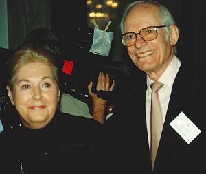 Marilyn, left in black clothing, and Alan, right in suit, smiling 