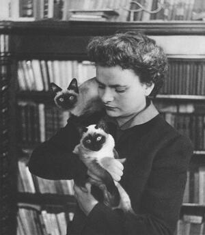 Ella Morante in her apartment, holding two of her cats. 