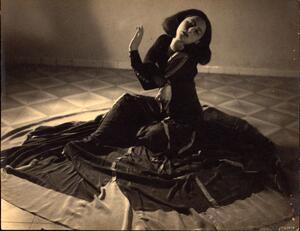 Gertrud Kraus posing, sitting on the floor, with the skirt of her long dress spread out in a circle around her