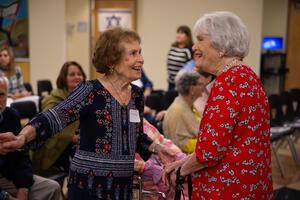 Two older women smiling and engaging with each other