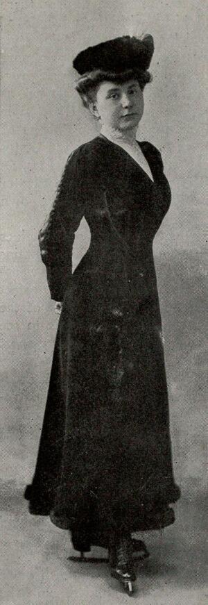 Lily Kronberger wearing ice skates, a long dress, and a hat