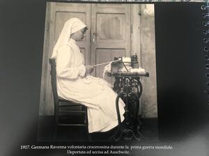 Germana Ravenna, in white, sitting at a table and working