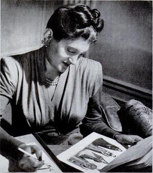 Nettie Rosenstein holding a pencil and looking at a fashion plate featuring four dresses