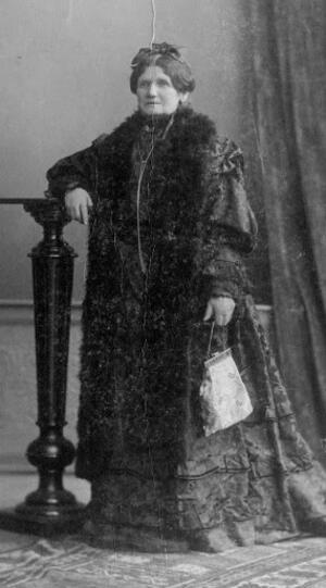 Full-length portrait of Pauline Wengeroff, wearing a floor-length dress and a fur drape