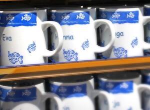 souvenir name mugs featuring illustrated fish. Names "Eva" and "Hanna" are on the mug.