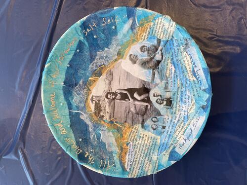 Plate with blue tissue paper, black and white portraits, and text