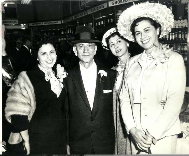 Joel Russ surrounded by his daughters Anne, Hattie, and Ida all smiling for the photo in their shop