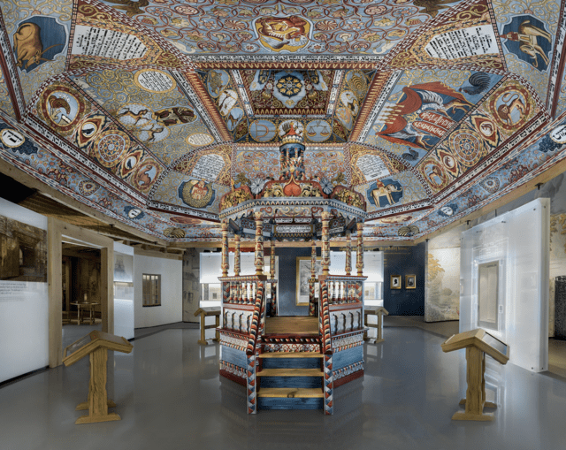 Reconstruction of the colorful painted ceiling, timber-frame roof, and bimah of the wooden synagogue