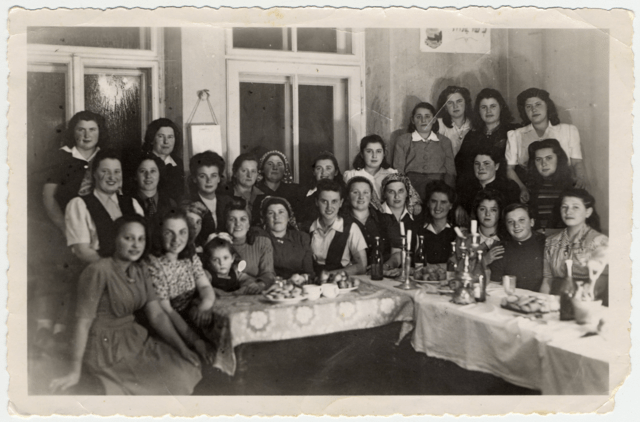 27 women and a child pose for group photo around a table in DP Camp Bad Bastein
