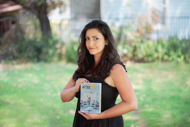 Photo of Emily Barth Isler Holding Her Book, "After/Math"