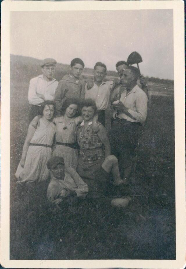 A group of six boys and three girls pose for a photo with arms wrapped around one another.