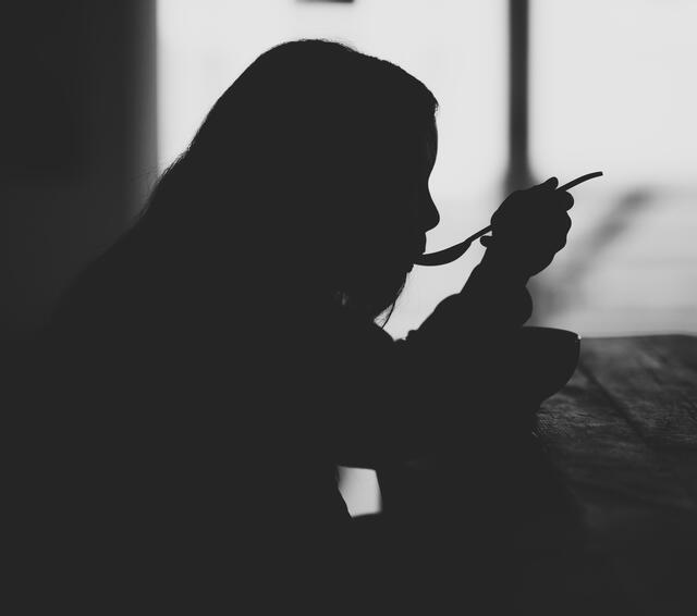 Silhouette of Girl Eating from a Spoon