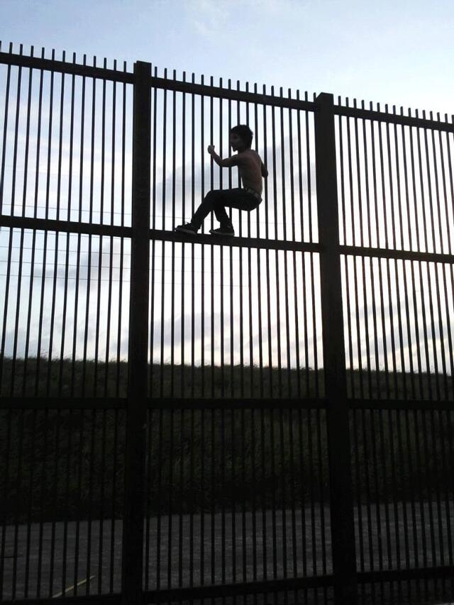 A Child Climbing a Fence at Mexico-US Border
