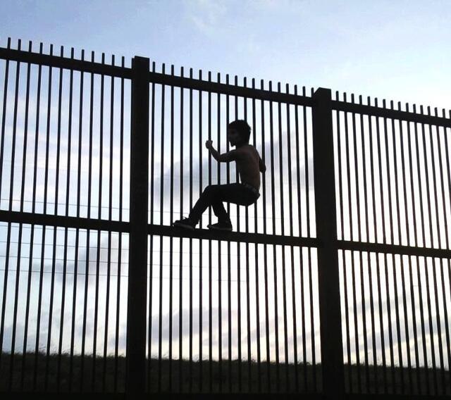 A Child Climbing a Fence at Mexico-US Border Cropped