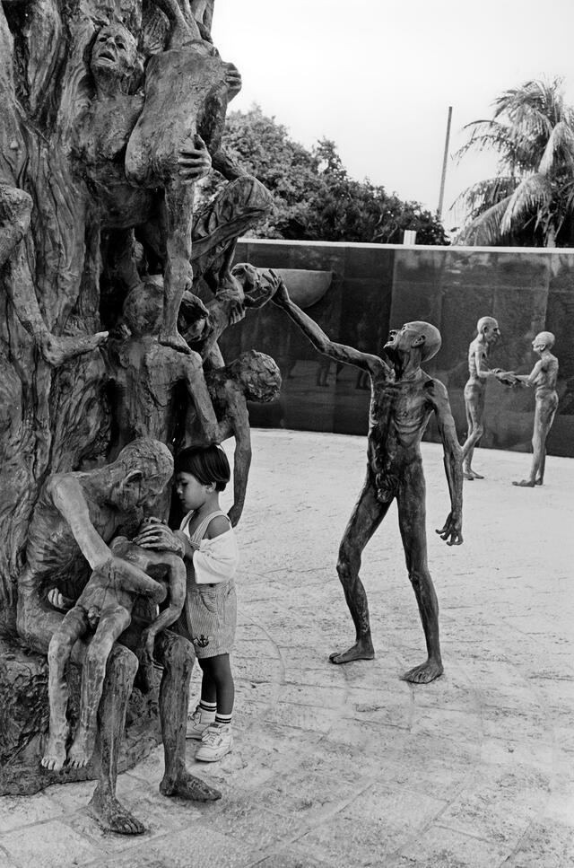 Photo of girl touching figure in Miami beach Holocaust memorial