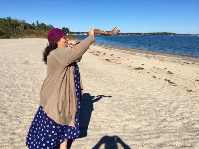 Rabbi Minna Bromberg Blowing a Shofar on the Beach