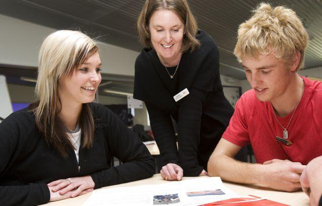 Stock image of a teacher working with students.