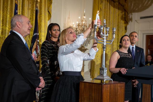 Rabbi Rachel Isaacs lighting the menorah at the White House with President Barack Obama and First Lady Michelle Obama on December 14, 2016.